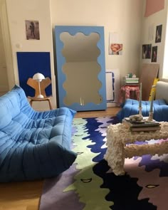 a living room filled with furniture and a large mirror on the wall next to it