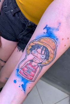 a person with a tattoo on their arm and the image of an anime character is painted on it