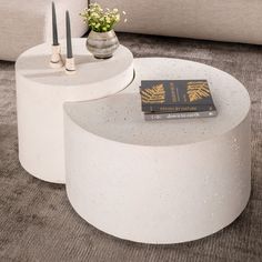 two white tables with books on them in a living room