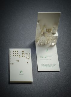 a white business card sitting on top of a table next to an open envelope with cut out letters