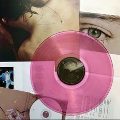 a pink vinyl record sitting on top of a table next to pictures and other items