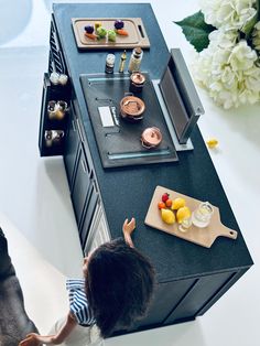 a little boy standing in front of a kitchen counter with food on top of it