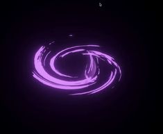 a purple circular object in the dark with some writing on it's side and an arrow pointing up