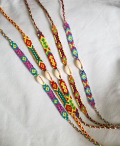 multicolored beaded necklaces with wooden beads on white fabric background, closeup