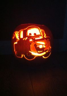 a pumpkin carved to look like the character from cars is lit up in the dark