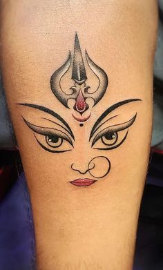 a woman's leg with a tattoo design on the side of her thigh and eyes