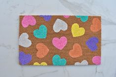 a door mat with hearts on it sitting on a marble counter top next to scissors