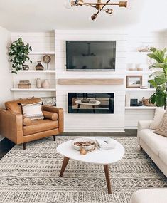 a living room with two couches and a television on top of a fireplace mantel