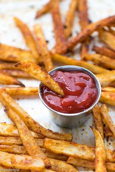 french fries with ketchup in a small metal bowl