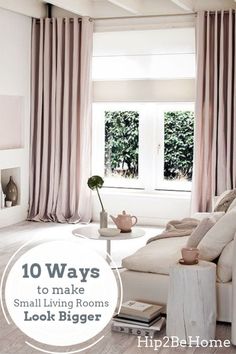 a living room filled with furniture and a window covered in pink drapes next to a white coffee table