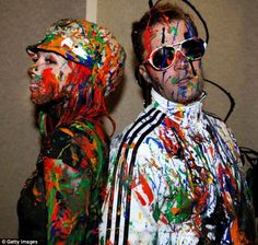 two people with paint all over their face and body are standing next to each other