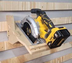 a cordless circular saw is being used to cut plywood planks on the wall