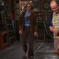 two men are walking in an old garage