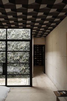 a bedroom with black and white tiles on the ceiling, windows open to let in natural light