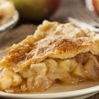 a slice of apple pie on a white plate