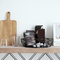 a wooden cutting board sitting on top of a table next to two glasses and a tray