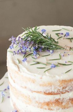 a close up of a cake with lavender sprigs on top and frosting