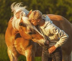 a man is kissing the face of a horse