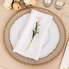 a place setting with napkins and flowers on it