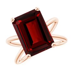 a ring with an emerald cut red stone in the center and two gold rings around it