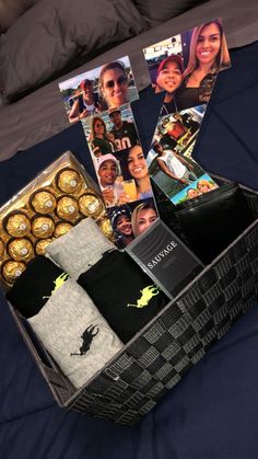 an open box containing chocolates, photos and other personalized items on a bed