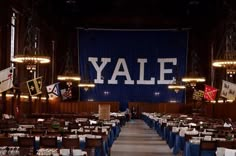 tables and chairs are set up in front of a blue wall with the word yale on it