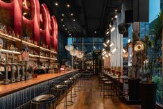 an empty bar with lots of stools and lights hanging from the ceiling above it