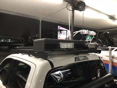 the back of a truck with luggage strapped to it's roof rack in a parking garage