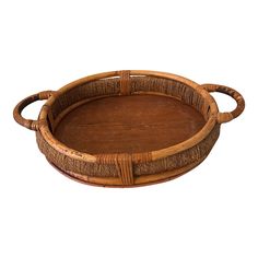 a round wooden tray with handles and wicker trimmings on the rim, isolated against a white background