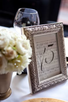 the table is set with an old fashioned clock and flowers in vases on it