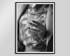 a black and white photo of a woman holding a glass of wine with her hand