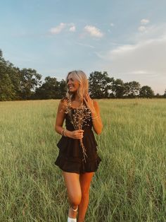 a woman is walking through the tall grass