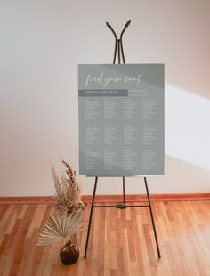 an easel with a sign on it in the middle of a wood floored room