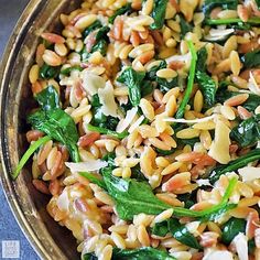 a bowl filled with rice and spinach on top of a table