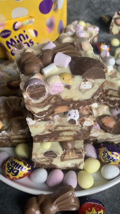 several pieces of cake sitting on top of a plate next to chocolate eggs and candy