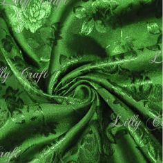 a green satin fabric with flowers on it