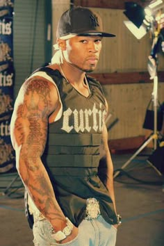 a man with tattoos standing in front of a camera