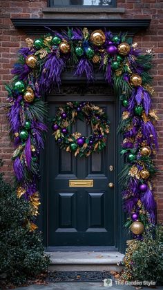 a green door with purple and gold decorations on the front entrance to a brick building