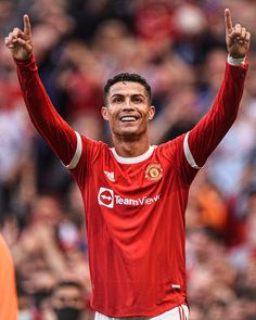 a soccer player is holding his hands up in the air and smiling at the camera