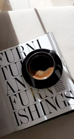 a cup of coffee sitting on top of a magazine