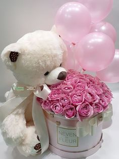 a teddy bear sitting next to a bucket filled with pink roses and balloons in the shape of a heart