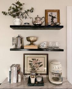 two shelves with various items on them and one shelf holding coffee cups, teapots and other things