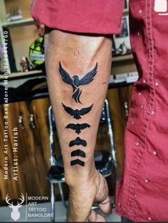 a man with a tattoo on his leg that has birds and arrows in the middle