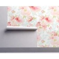 the wall paper has pink flowers on it and is next to a roll of toilet paper