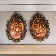 two ornate framed paintings on the wall