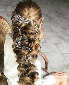 the back of a woman's head wearing a wedding hair vine with pearls on it