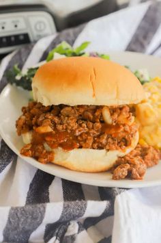 a sloppy joe sandwich on a plate with macaroni and cheese