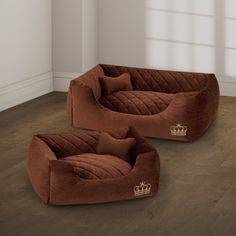 two brown couches sitting on top of a wooden floor