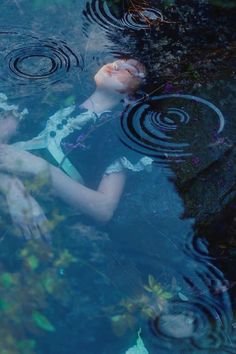 a woman floating on top of a body of water