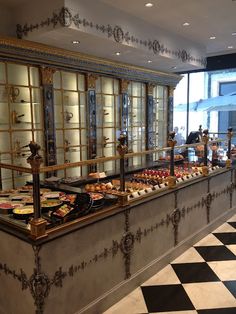 a buffet with lots of different types of food on it's counter top and black and white checkered flooring